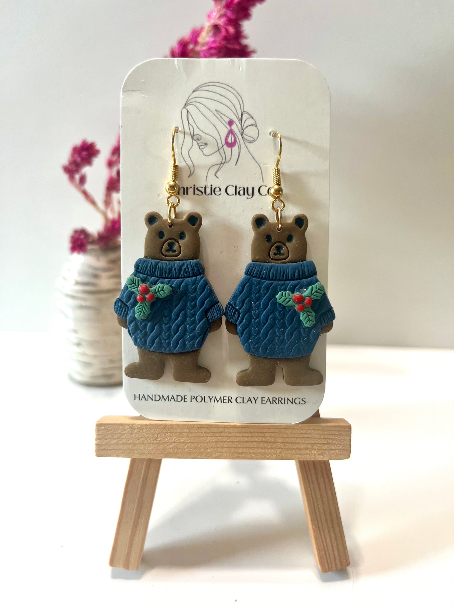 Christmas-Bear wearing blue sweater with holly